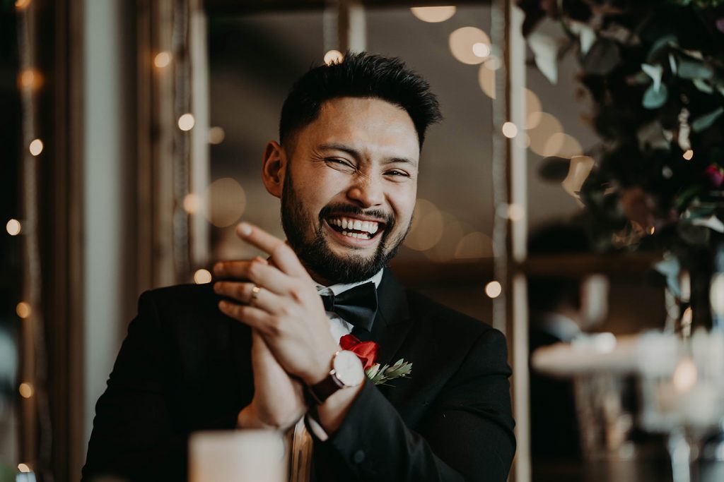 groom laughing at the wedding speech