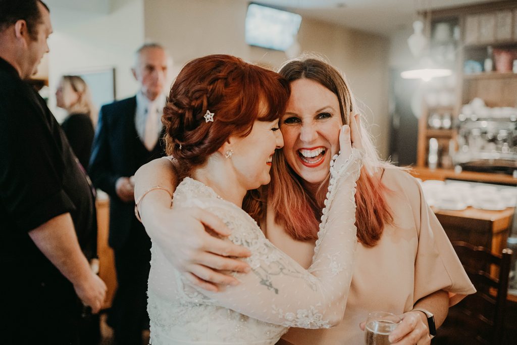 Bride and her sister hugging.