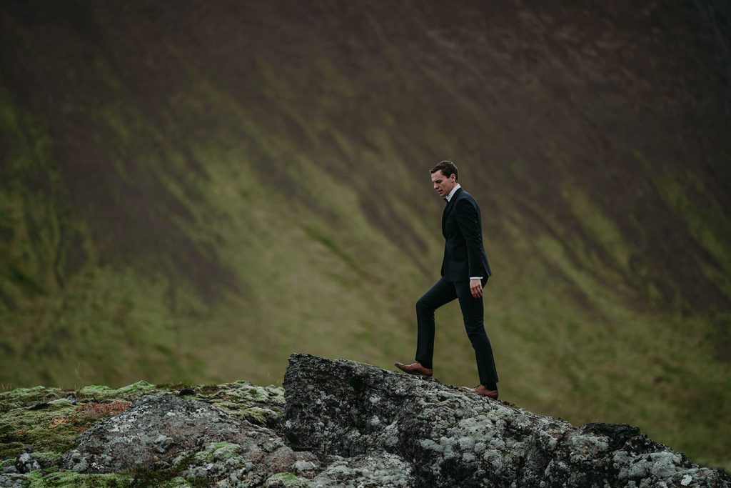 Groom walking on a rock at an elopement in Iceland