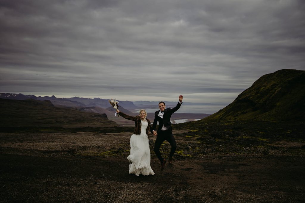 A couple jumping for joy of being just married on an Iceland elopement.