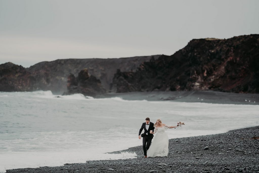 A couple running down a beach